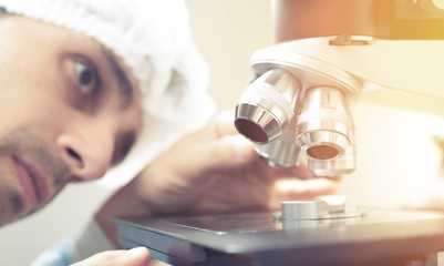Young Female Scientist Working with Microscope