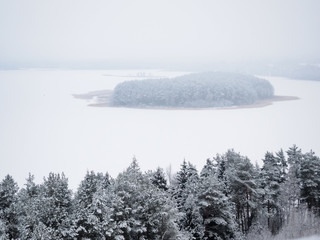 Winter view of the lake and trees in Lithuania. Panorama of landscape in the fog.