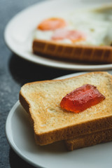 Strawberry jam on bread With blurred breakfast background.