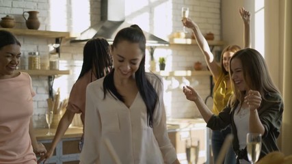 Cheerful funny group of 5 women friends having fun in the kitchen. girls drink champagne and dance 4K