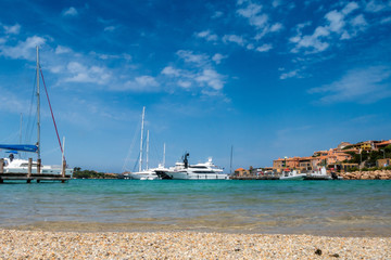 italian harbor with blue sky, clear water and boats on the background