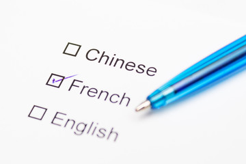 Chinese, French, English - checkmark with pen on paper.