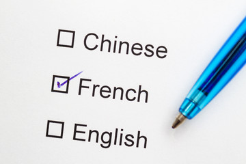 Chinese, French, English - checkmark with pen on paper.