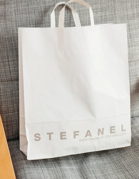 PARIS, FRANCE - OCT 24, 2016: White shopping bag with Italian fashion brand STEFANEL logotype on the armchair