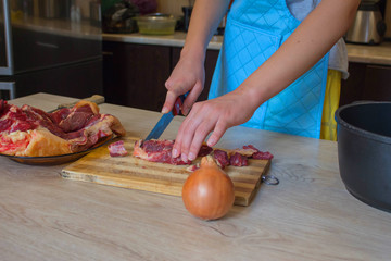 Butcher cutting meat on kitchen. Man in the kitchen cutting a piece of meat