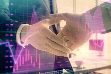 Fototapeta na wymiar Multi exposure of financial graph on office background with two businessmen handshake. Concept of success in business