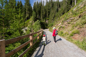 enfant en v&eacute;lo et randonneuse en montagne