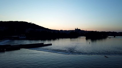 Night timelapse of Prague with Prague castle in background. View across river Vltava to Castle.