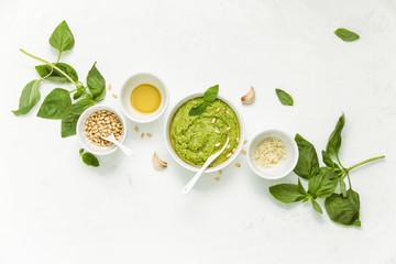 Pesto sauce and ingredients on white background, view from above