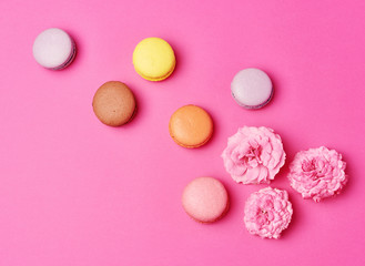 Obraz na płótnie Canvas macarons with cream and a pink rose bud with scattered petals
