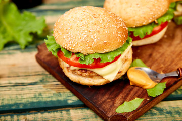 Craft beef burger  on wooden table isolated on black background..Street food, fast food. Homemade juicy burgers with cheese and  on the wooden table. Copy space.