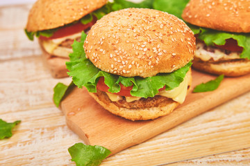 Craft beef burger  on wooden table on light background. Street food, fast food. Homemade juicy burgers with cheese and  on the wooden table. Copy space.