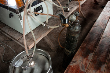 Movable draft beer pouring equipment for outdoor party or picnic. Close up image of manometers, valves, pressure vessel, pipes, keg and cooler system. Rustic weathered elements on wooden table