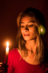 Fototapeta premium blonde girl with candle in red light