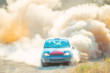 Obraz na płótnie Canvas Rally Car is Driving with a Big Cloud of Dust