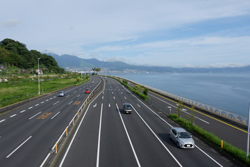 晴れた日の別府湾の国道、大分川から撮影、別府市が見える