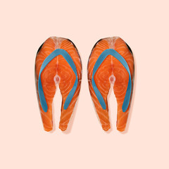 Let's go to the beach. Slippers as a salmon steaks on coral background. Negative space to insert your text. Modern design. Contemporary art collage. Concept of summertime, holiday, resort.