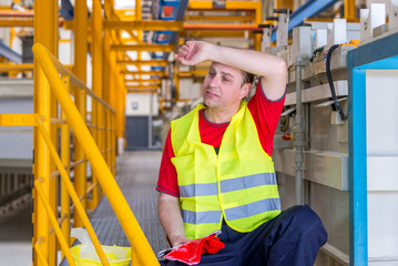 Tired unsatisfied worker wipes the sweat of the forehead