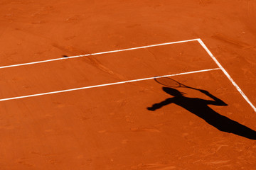 A tennis Clay court and the shadow of a player 