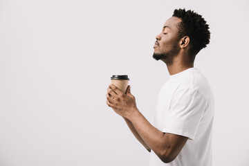 side view of happy african american man holding paper cup isolated on white