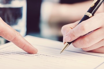 Male Hand Pointing a Place to Sign a Paper
