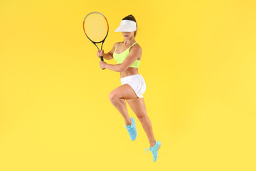 Jumping female tennis player on color background