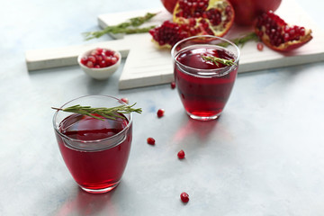Glasses of tasty pomegranate juice on table