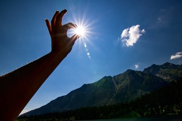 sun in hand at mountains