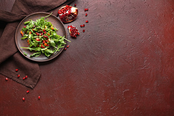 Plate with tasty arugula salad on color background