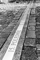 15th meridian line in cobbled street of Jindrichuv Hradec, Czech Republic. Inscription 15. polednik means 15th meridian