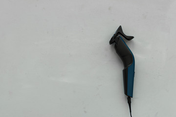 Electric hair trimmer on gray wooden background. Copy space. Top view. Flat lay