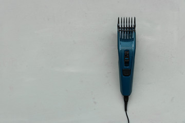 Electric hair trimmer on gray wooden background. Copy space. Top view. Flat lay