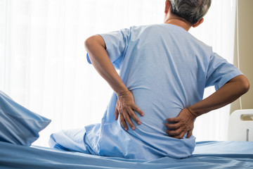 Senior male patient having back ache on hospital bed