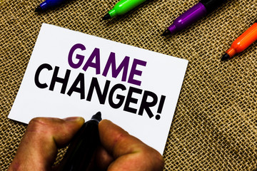 Writing note showing Game Changer. Business photo showcasing Sports Data Scorekeeper Gamestreams Live Scores Team Admins Man hand holding marker white paper communicating idea Jute background