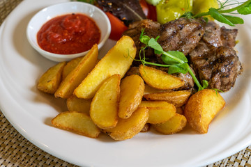 Grilled meat (kebab) with vegetables and sauce
