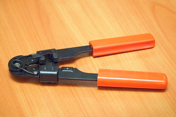 Crimping Tool for computer plugs on wooden background