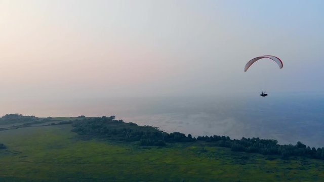Parawing is gliding high above the water. Skydiver flies in sky.