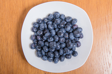  Clean freshly picked blueberries on white plate - close up studio shot. ( Ingredients:  Antioxidants , Vitamin C, Antioxidant)