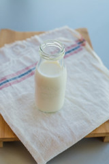 Bottle of milk on light wooden background
