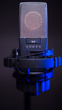 studio condenser microphone, isolated on gradient. with blue light