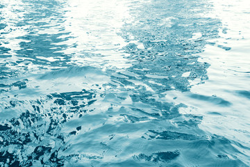 Water surface with ripples and sunlight reflections