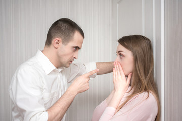 Angry man, pointing her finger against her wife, intimidates, unhappy married couple, relationships...