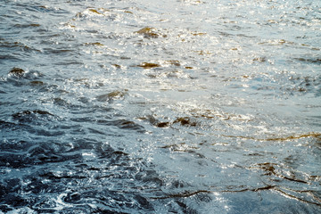 Water surface with ripples and sunlight reflections