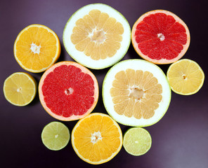 Naklejka na ściany i meble cut pieces of different citrus fruits on dark background