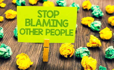 Handwriting text Stop Blaming Other People. Concept meaning Do not make excuses assume your faults guilt Paperclip retain written words yellow paper paper lobs laid on wooden floor