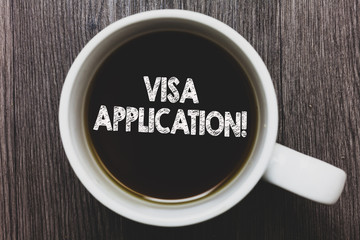 Word writing text Visa Application. Business concept for Form to ask permission travel or live in another country Black coffee with coffee mug floating texts on gray black wooden desk