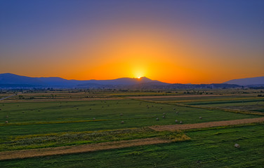 Aerial view of the fields near Sinj countryside and the sun touching horizon