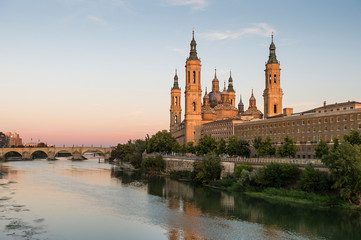 View of the cathedral of El Pilar de Zaragoza, next to the river Ebro, at sunset.