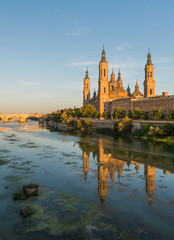 View of the cathedral of El Pilar de Zaragoza, next to the river Ebro, at sunset.