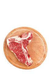 Raw t-bone steak on a wooden board on a white background.